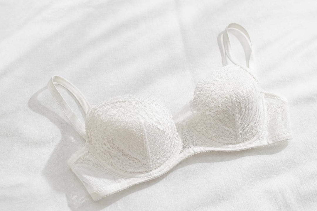 A white lace bra on white linen
